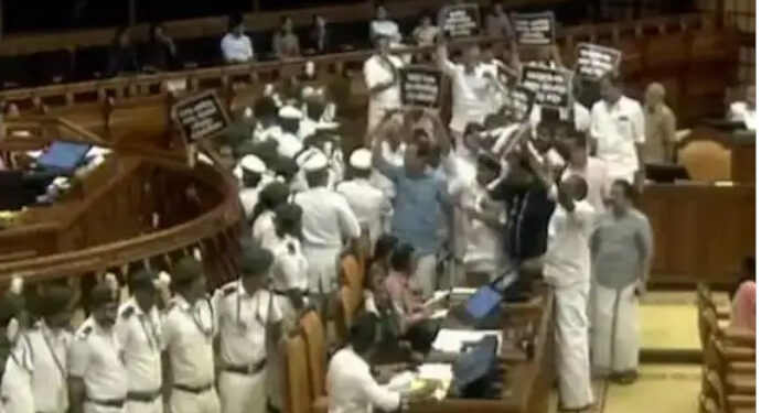 ബാനർ-പിടിച്ച്-നിയമസഭയുടെ-നടുത്തളത്തിലിറങ്ങി-പ്രതിപക്ഷം,-സീറ്റിലിരുന്നില്ലെങ്കിൽ-വി-ഡി-സതീശന്-മൈക്ക്-നൽകില്ലെന്ന്-സ്പീക്കർ,-വി-എൻ-വാസവന്റെ-രാജിയാവശ്യം-ശക്തം,-പിണറായി-വിജയന്റെ-ബോഡി-ഷെയ്മിങ്-പരാമർശത്തിനെതിരെയും-രൂക്ഷ-വിമർശനം